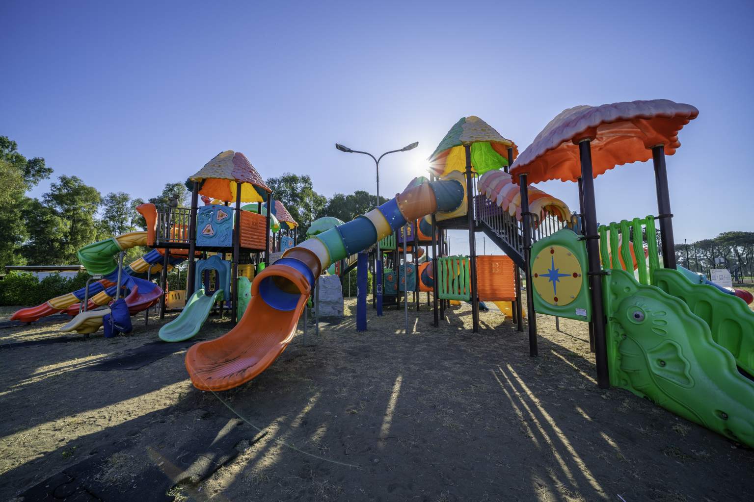 Six multi coloured slides and play house climbing frame with stairs to two little towers, at Village Roma Capitol campsite, Rome