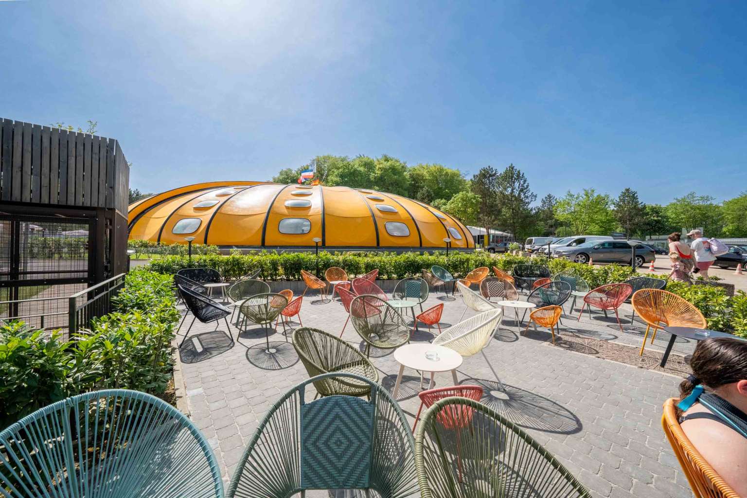 Bar terrace tables and chairs with a view of the dome pool cover at Hu Birkelt Village campsite