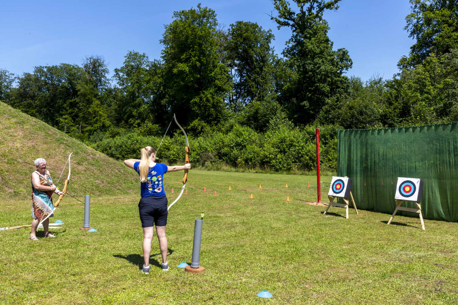 Lady having archery lesson at Hu Birkelt Village campsite in Luxembourg
