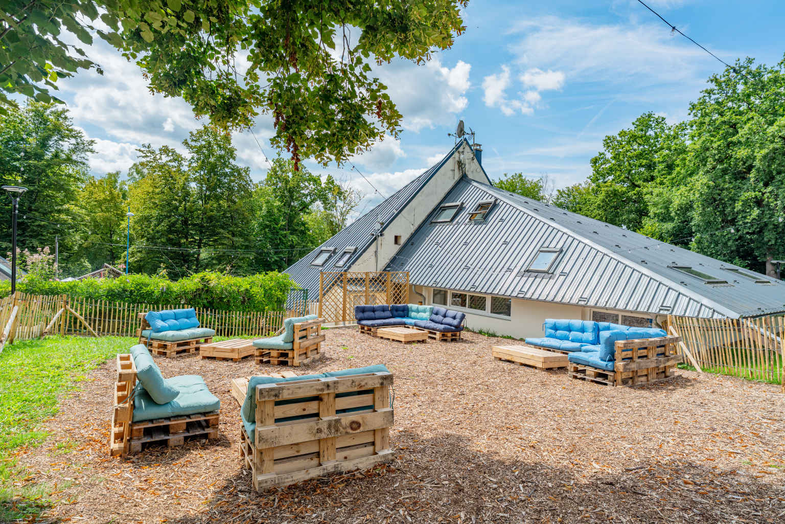 Chill out zone with outdoor sofa seating on a terrace above the reception at Lac des Vielles Forges campsite in the Ardennes