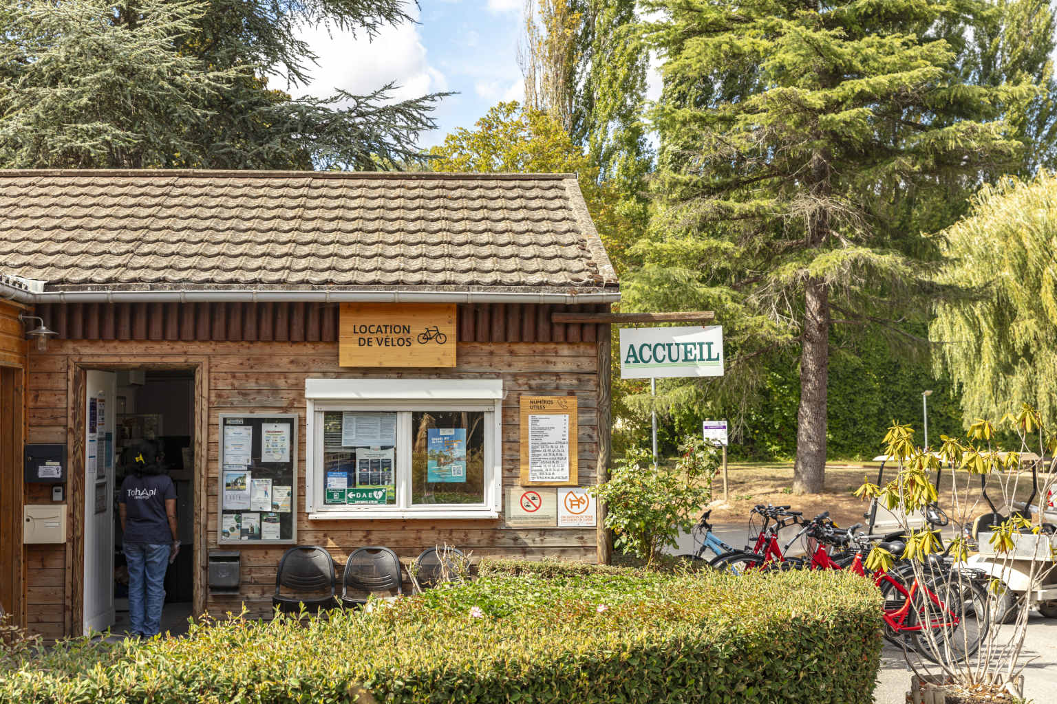 Customer entering the bike hire cabin at Les Fontaines campsite, Ivry-la-Bataille, France