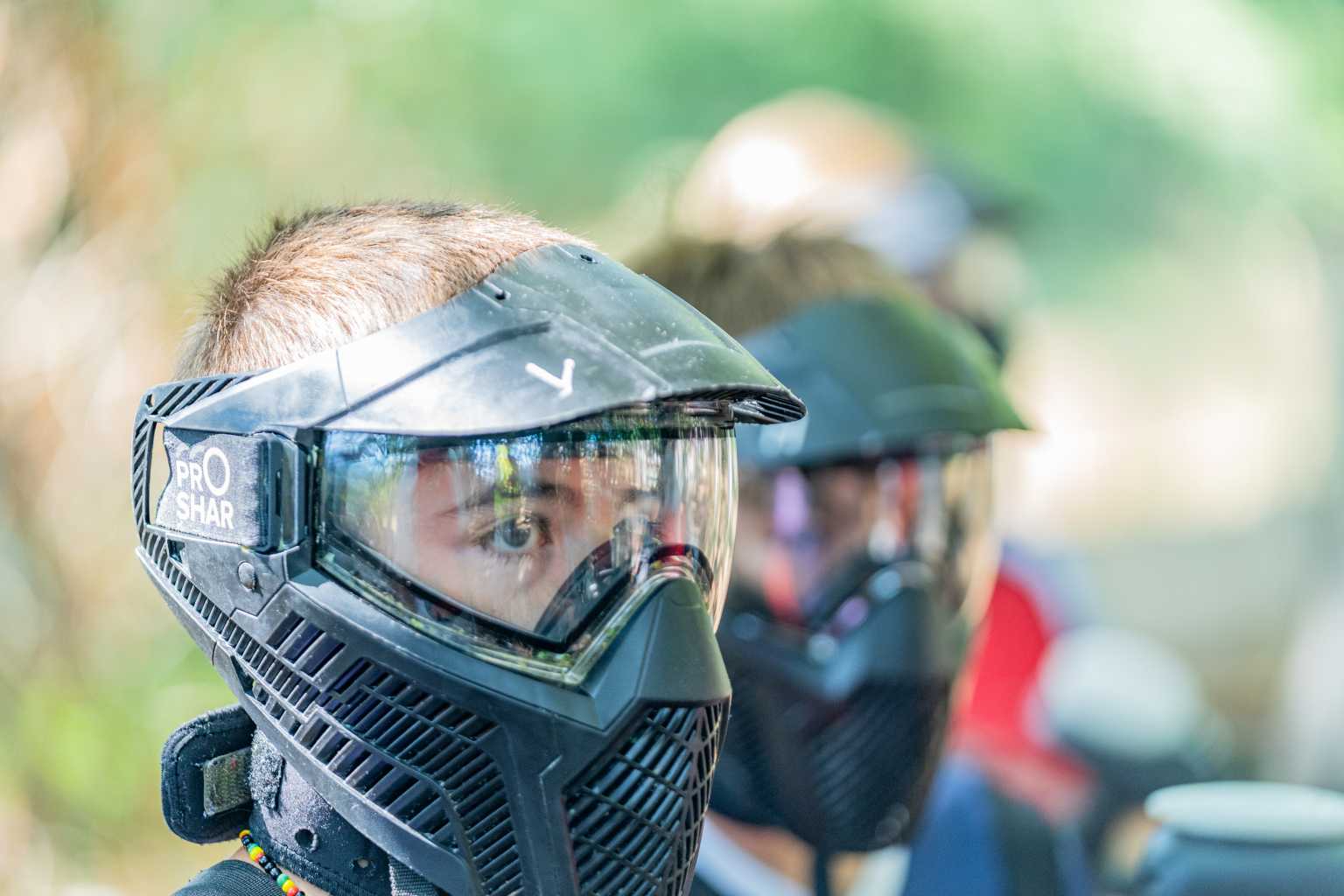 Kids with full face helmets on ready for games under the trees with the kids club at Domaine des Iscles campsite, in Provence