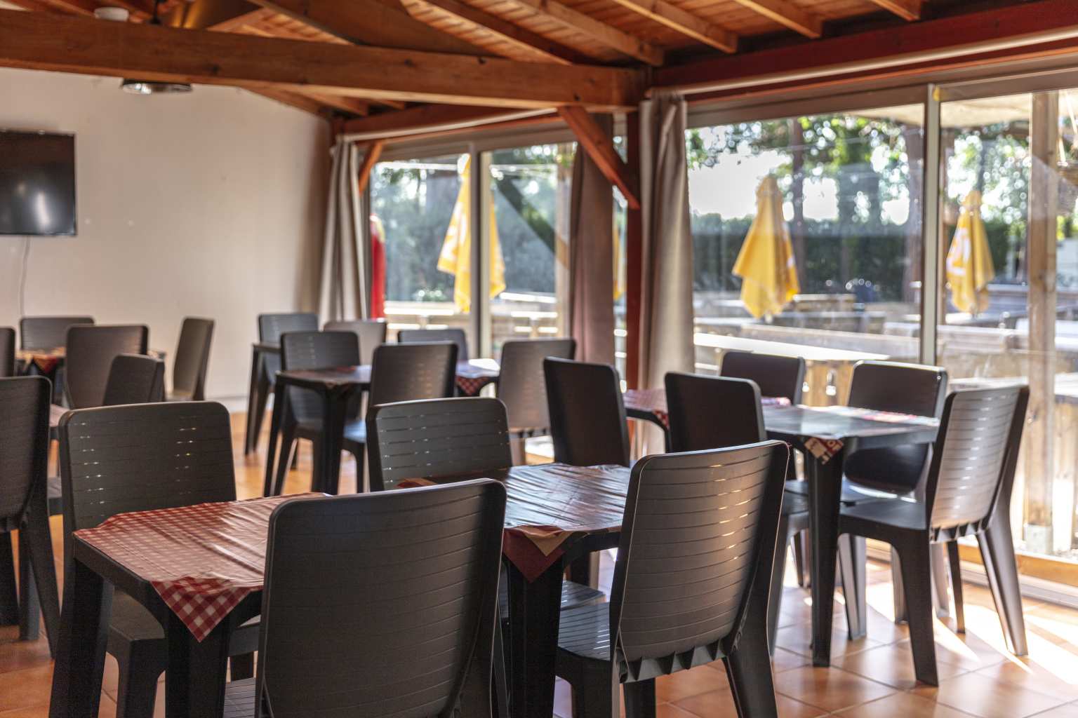 Empty tables and chairs inside the bar at Coeur de Vendée campsite in France