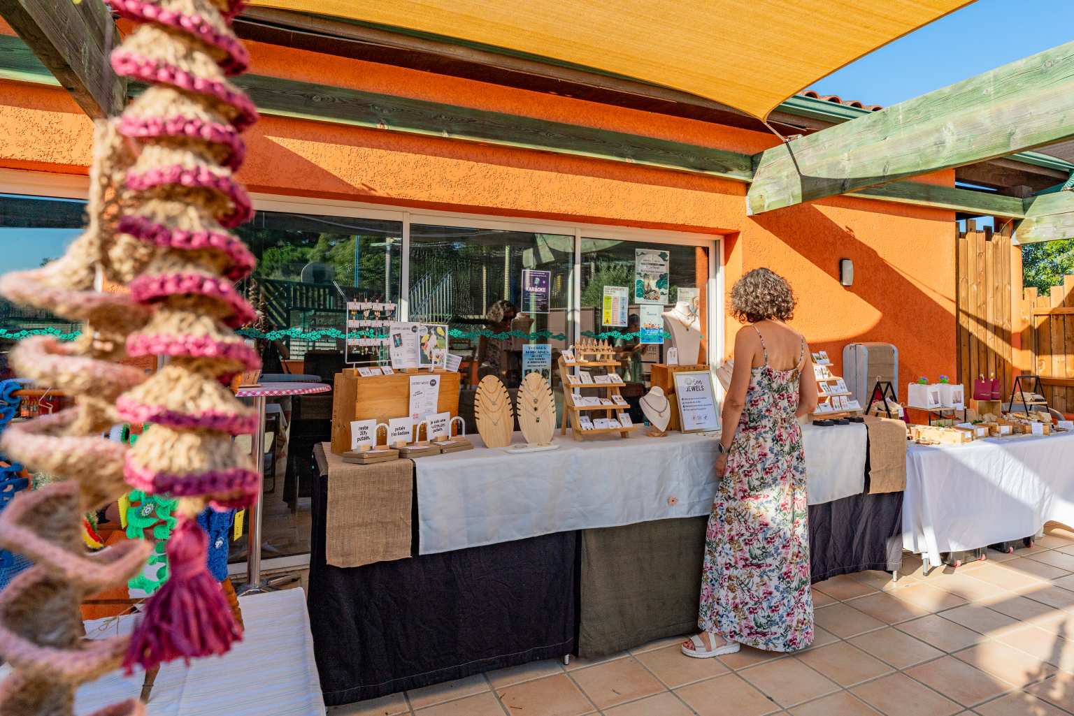 Lady looking at onsite market stall at Ma Prairie campsite in the Roussillon, France