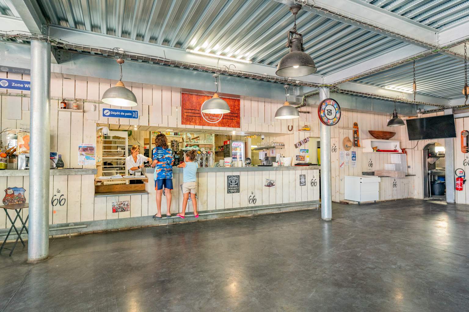 2 kids waiting at the snack bar counter at le Soleil de la Mediterranee campsite, Roussillon