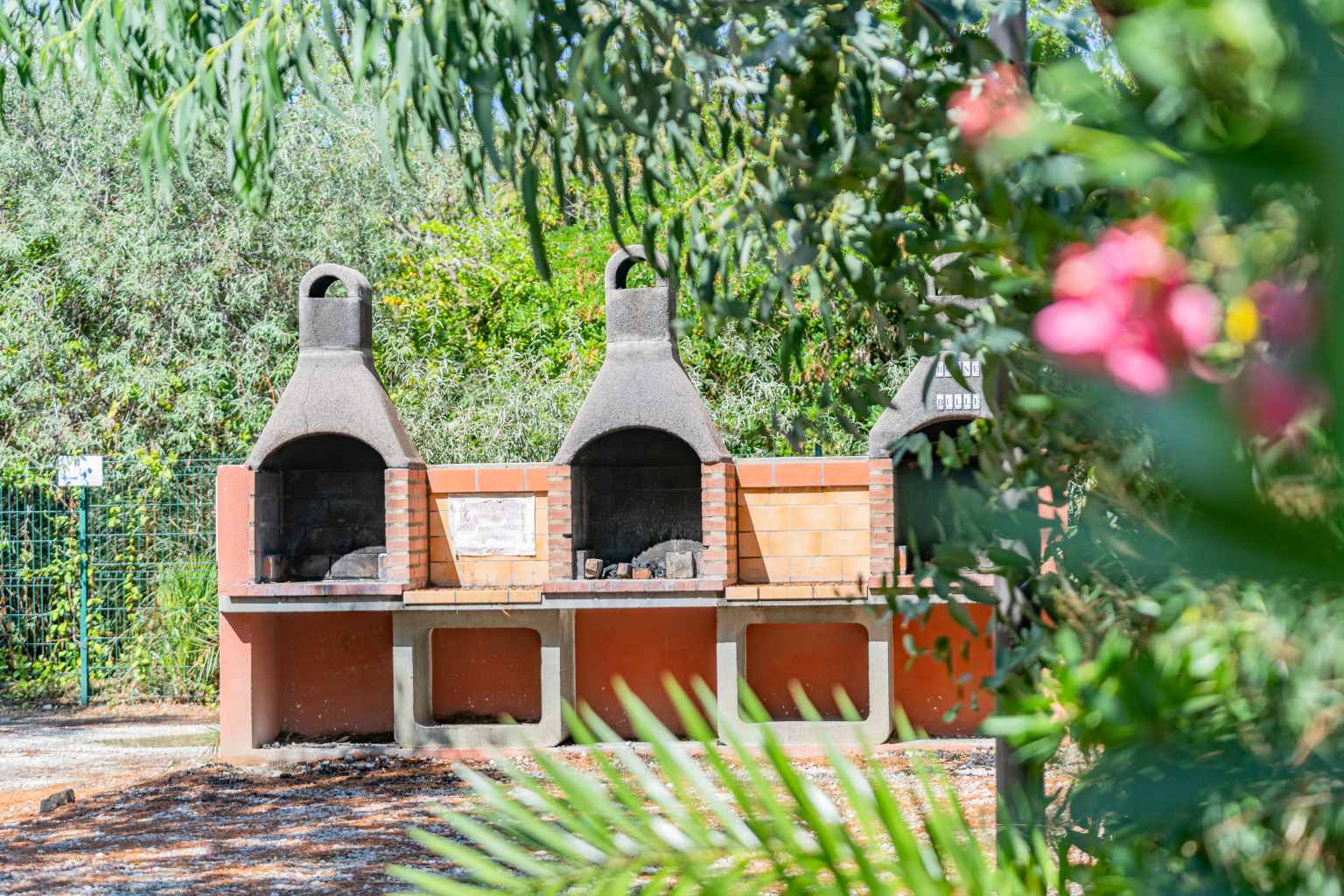 3 outdoor BBQs with chimneys, in a row,  at La Croix du Sud campsite in the Languedoc