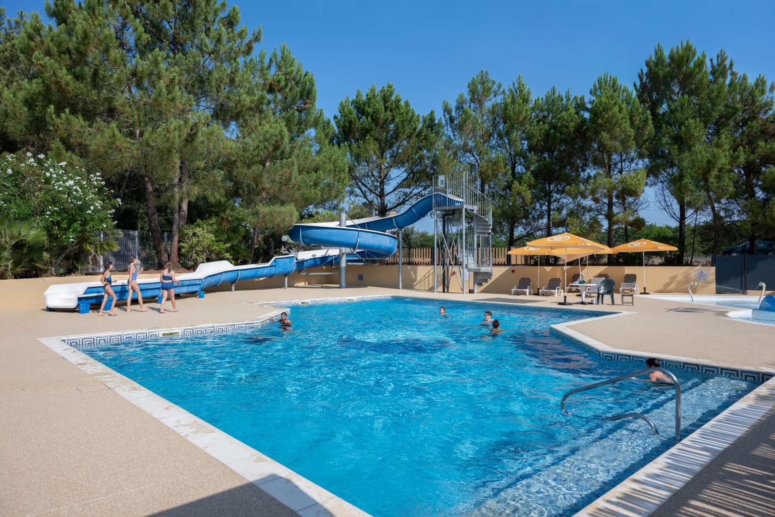 Main pool complex slides, surrounded by large trees at La Pointe du Médoc