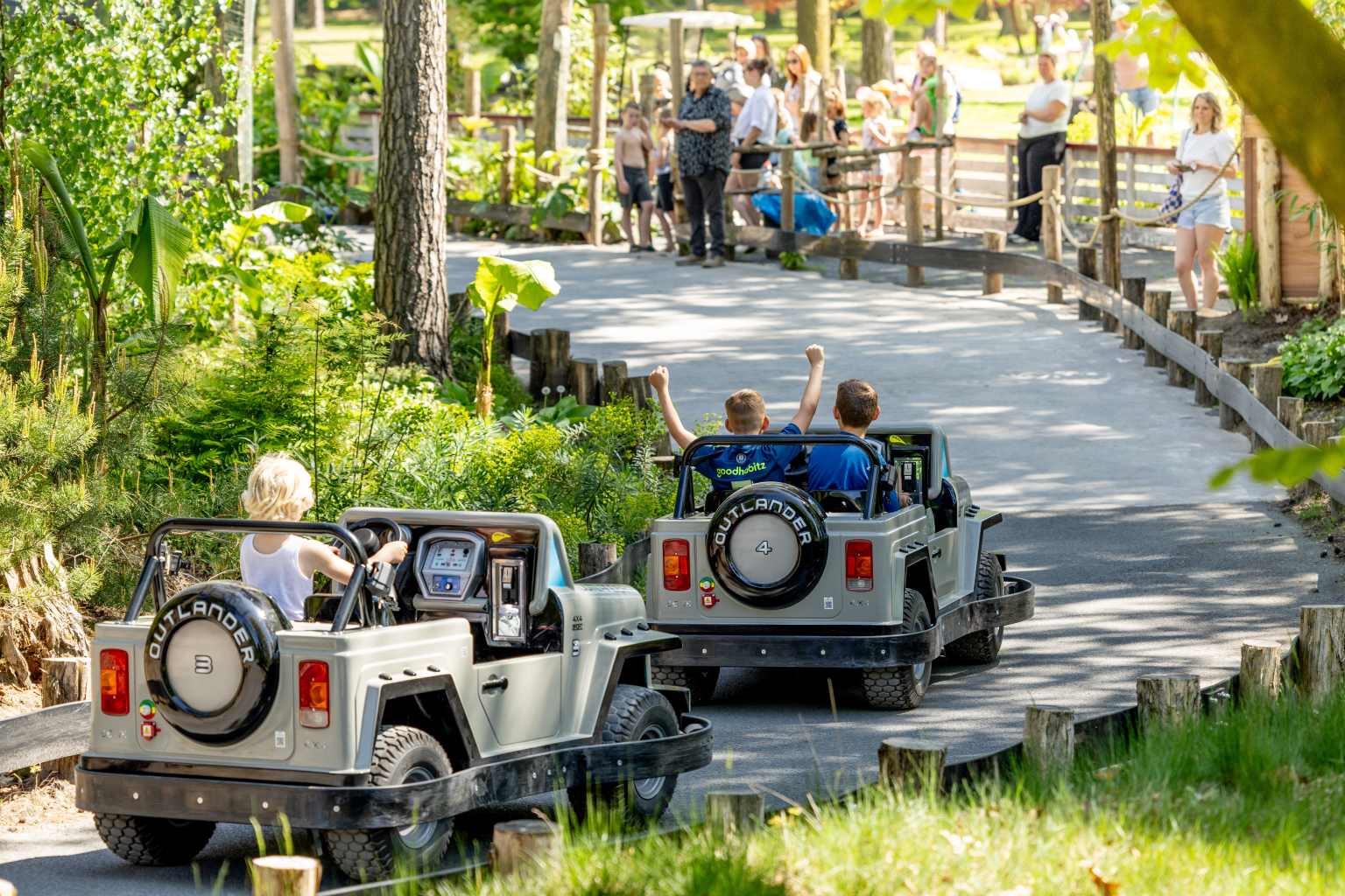 2 Jungle Cars, mini open topped electric kids cars, going round the outdoor track at Vakantiepark de Bergen campsite in the Netherlands