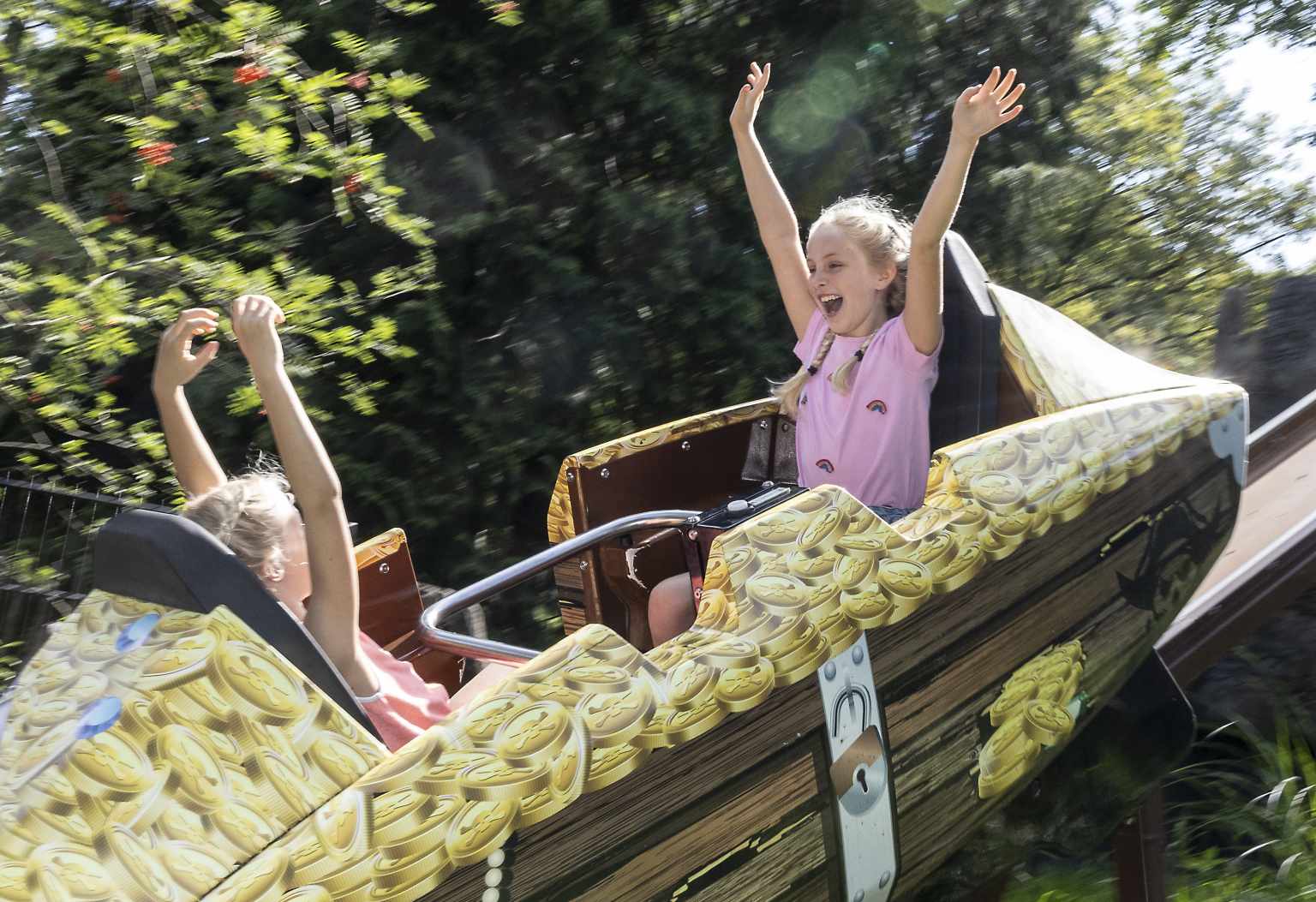 Kids on mini roller coaster ride for kids at the onsite adventure park at Vakantiepark de Bergen campsite, Netherlands
