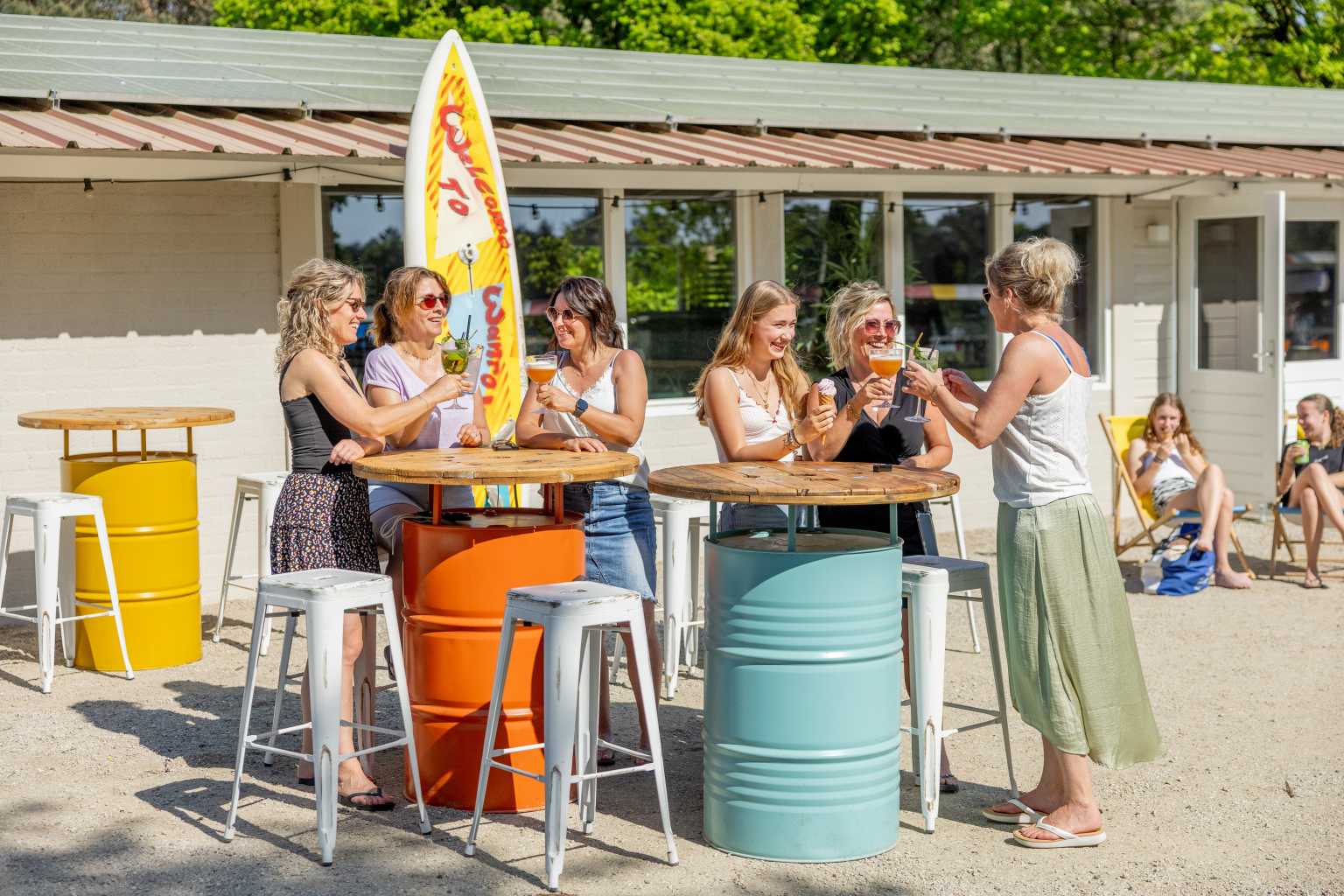 Customers standing at the take-away and outdoor bar tables at Vakantiepark de Bergen campsite in the Netherlands