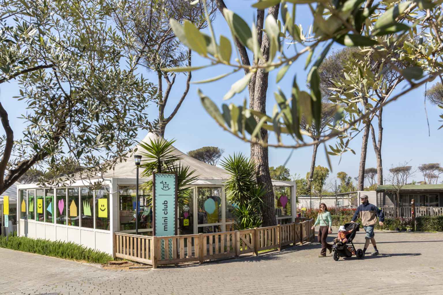 Family walking past the Mini Club area at Camping Fabulous Village near Rome