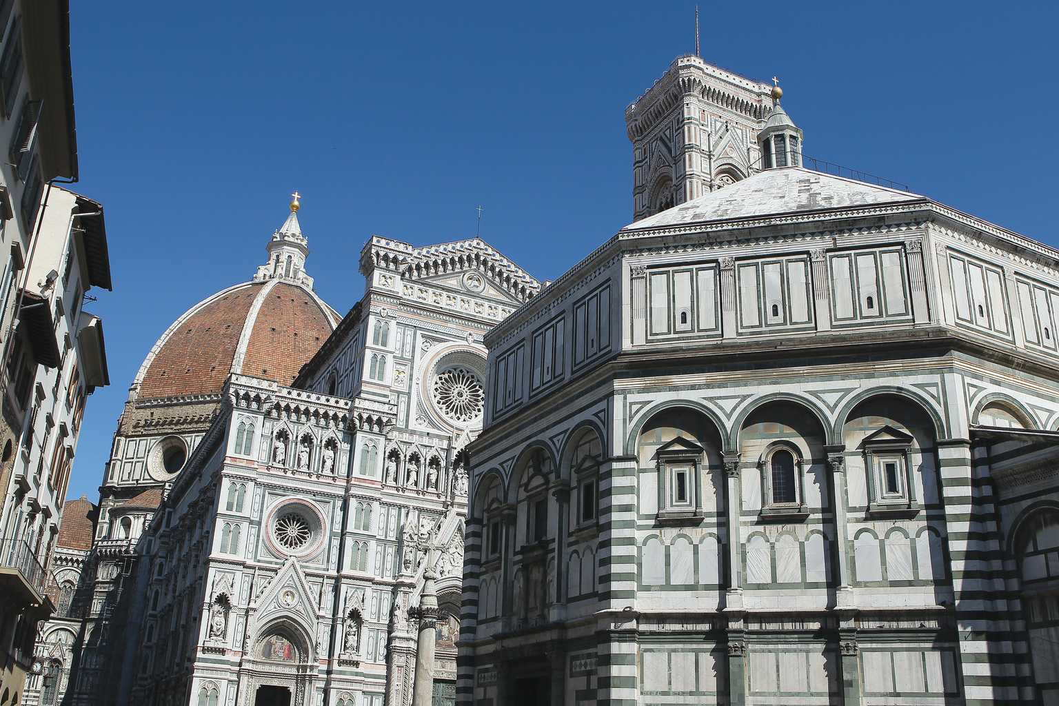 The Duomo cathedral in Florence showing the black and white stonework and the dome to the left