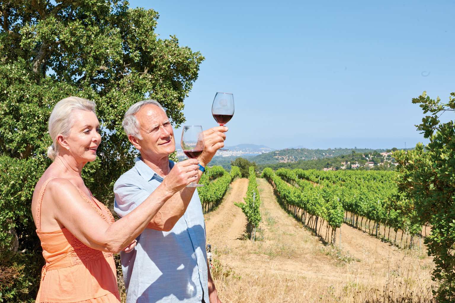 Ein älteres Paar genießt ein Glas Wein auf einem Weingut