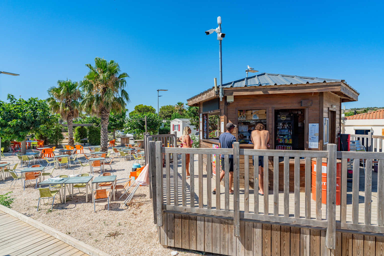 Customers at the bar cabin next to the outdoor terrace at Novela Port La Nouvelle campsite, Languedoc
