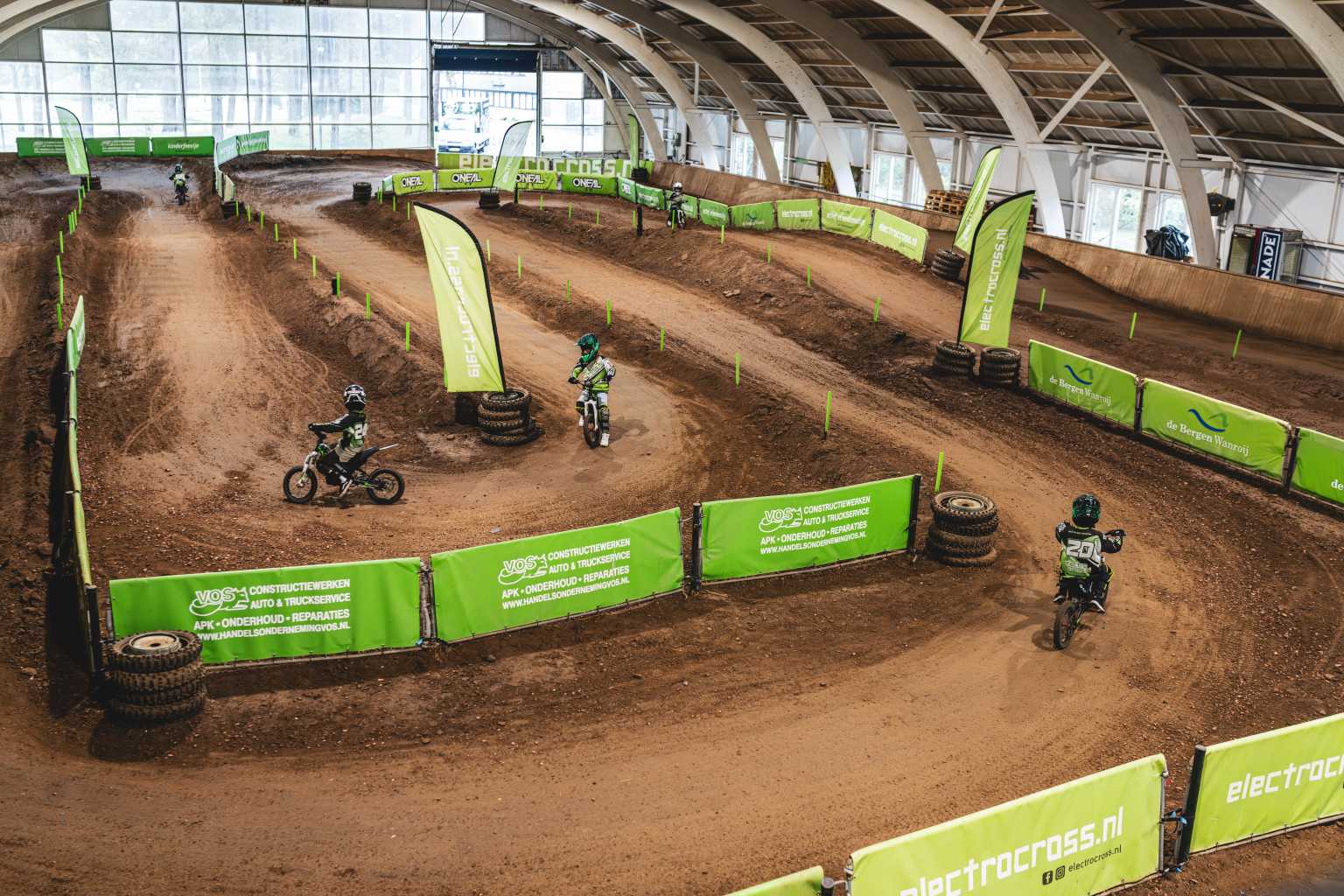 5 riders going round the indoor motorcross track at Vakantiepark de Bergen campsite in the Netherlands