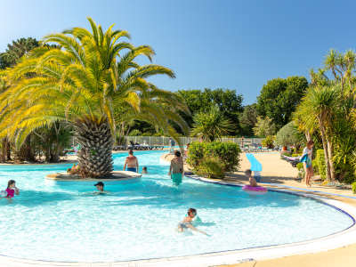 Palm trees and trees at the pool at la grande metairie, campsite, south brittany