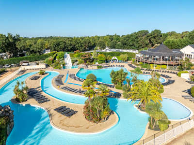 Lazy river snaking around to tobaggan waterslides, outdoor pool and circular restaurant at la grande metairie, campsite, south brittany