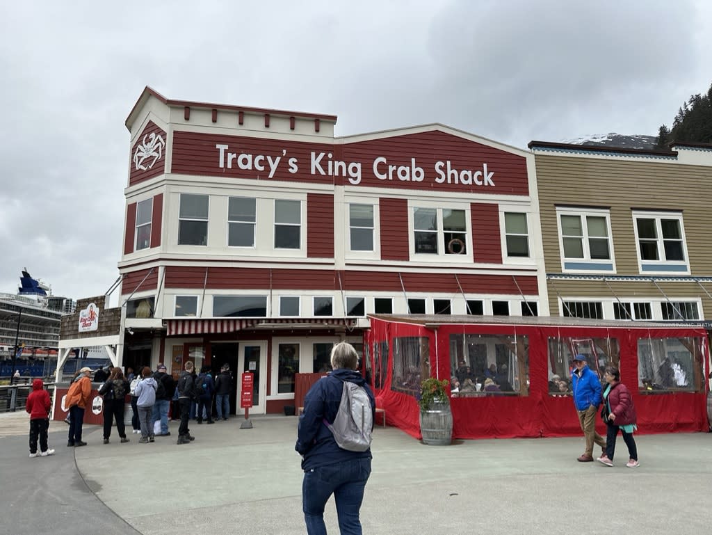 Exterior view of Tracy's King Crab Shack with a line of people outside.
