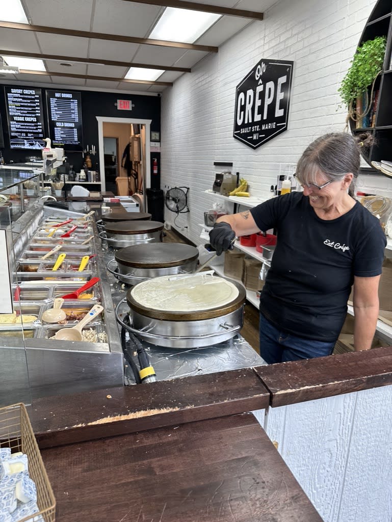 Employee preparing crepes in a crepe shop kitchen