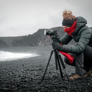 person in gray jacket and gray pants holding black dslr camera