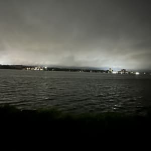 Night view of a lake with reflections and distant buildings