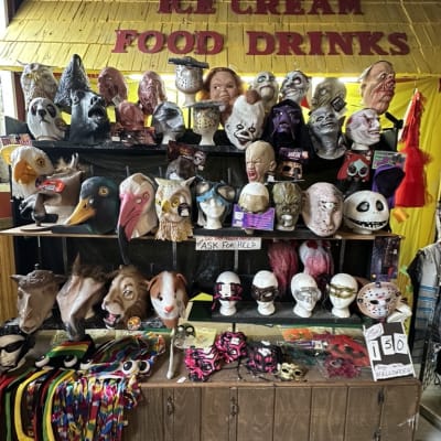 A display of various masks and costumes at a vendor booth.