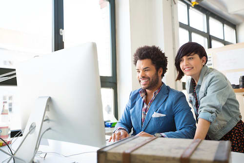 Two young designers working on a pc Young man and woman working together on new business projects at office. Businesspeople working on a computer.