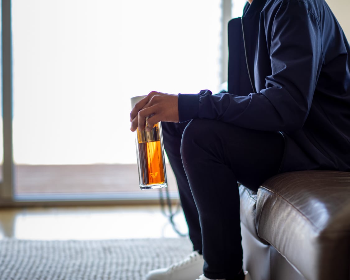 Male holding Ever Vessel Glass Multi with Infuser Strainer at home