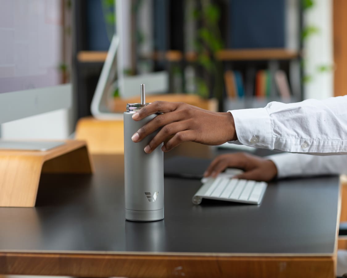Male picking up Ever Vessel Multi Plain Stainless water bottle from desk