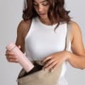 Female with an Ever Vessel Mini Rose water bottle putting into a bag