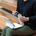 Female holding an Ever Vessel Mini Desert beige water bottle with the lid off