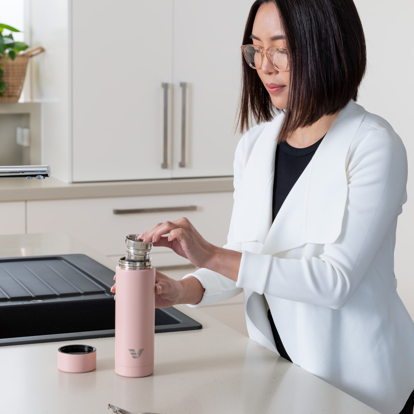 Lady using an Ever Vessel Multi Rose bottle and tea infuser strainer to brew a tea