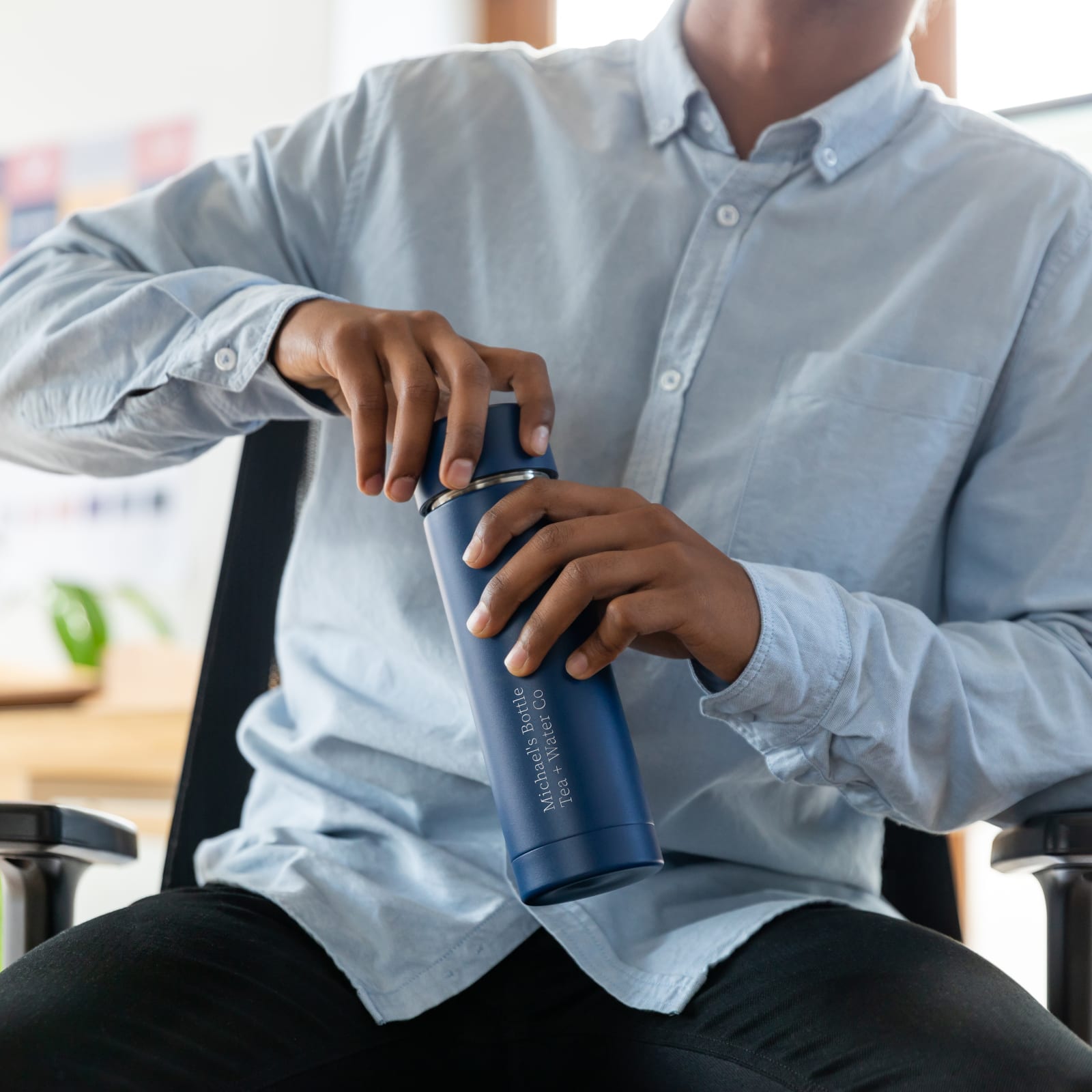 Male with a personalized Ever Vessel Multi Blue water bottle  at work