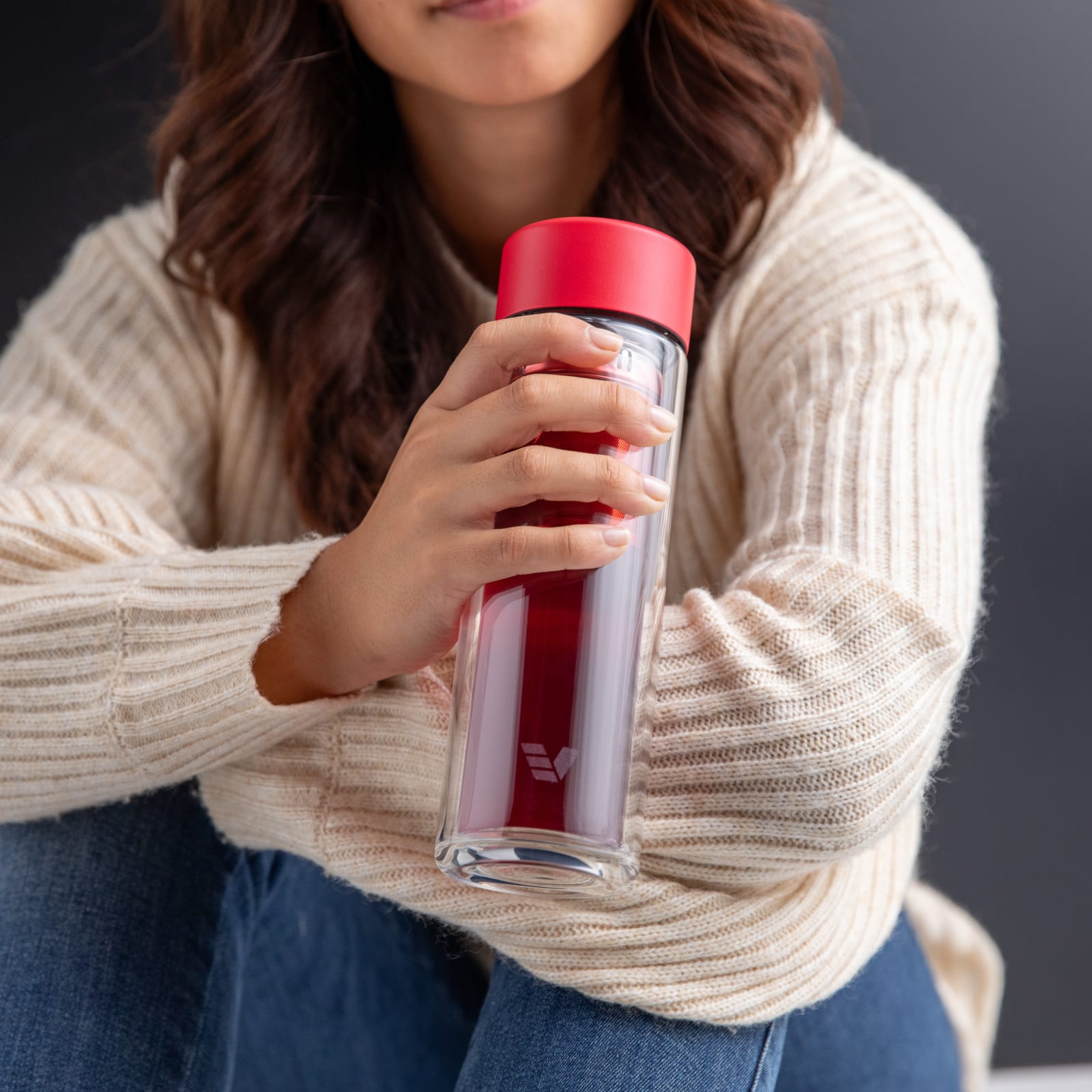 Female holding an Ever Vessel Glass Multi Red tea flask with berry tea inside