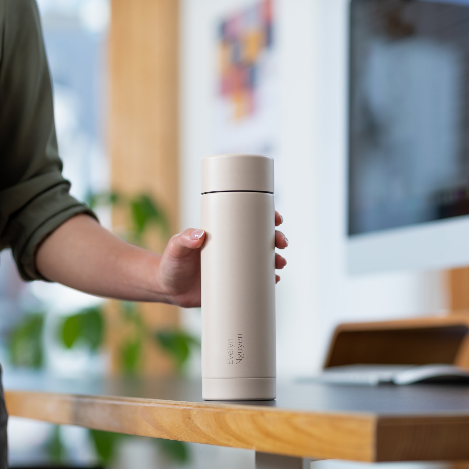 Female reaching for a personalized laser engraved Ever Vessel Multi Desert water bottle at work