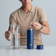 Ever Vessel Multi Blue vacuum insulated water bottle with iced water being poured in by a male