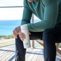 Male sitting on the deck holding an Ever Vessel Multi White Sand water bottle