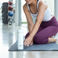 Lady at gym reaching for an Ever Vessel Multi White Sand water bottle