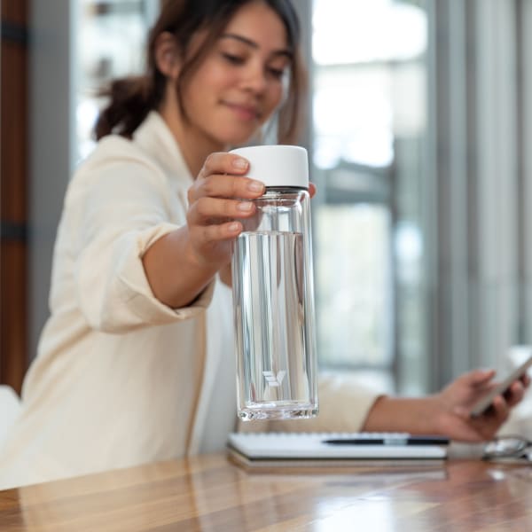 Female holding an Ever Vessel Glass Multi White tea flask