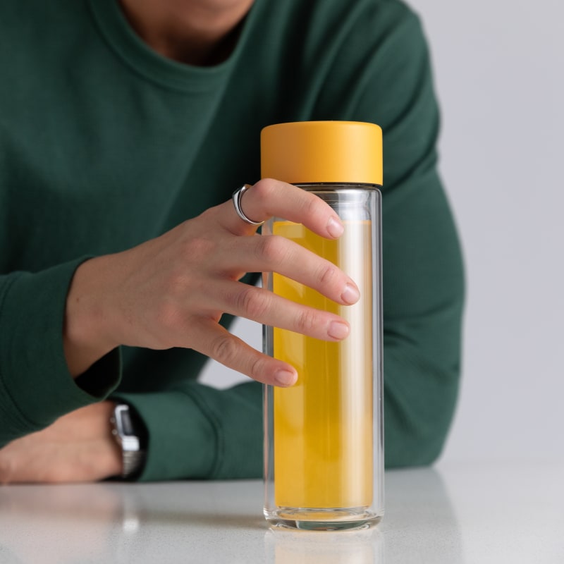 Male holding an Ever Vessel Glass Multi tea flask bottle with Yellow colored lid and bubble tea inside