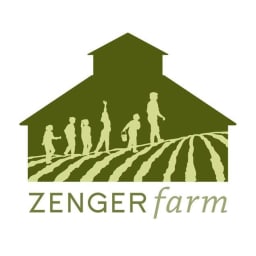 Green barn with children in a line lead by an educator