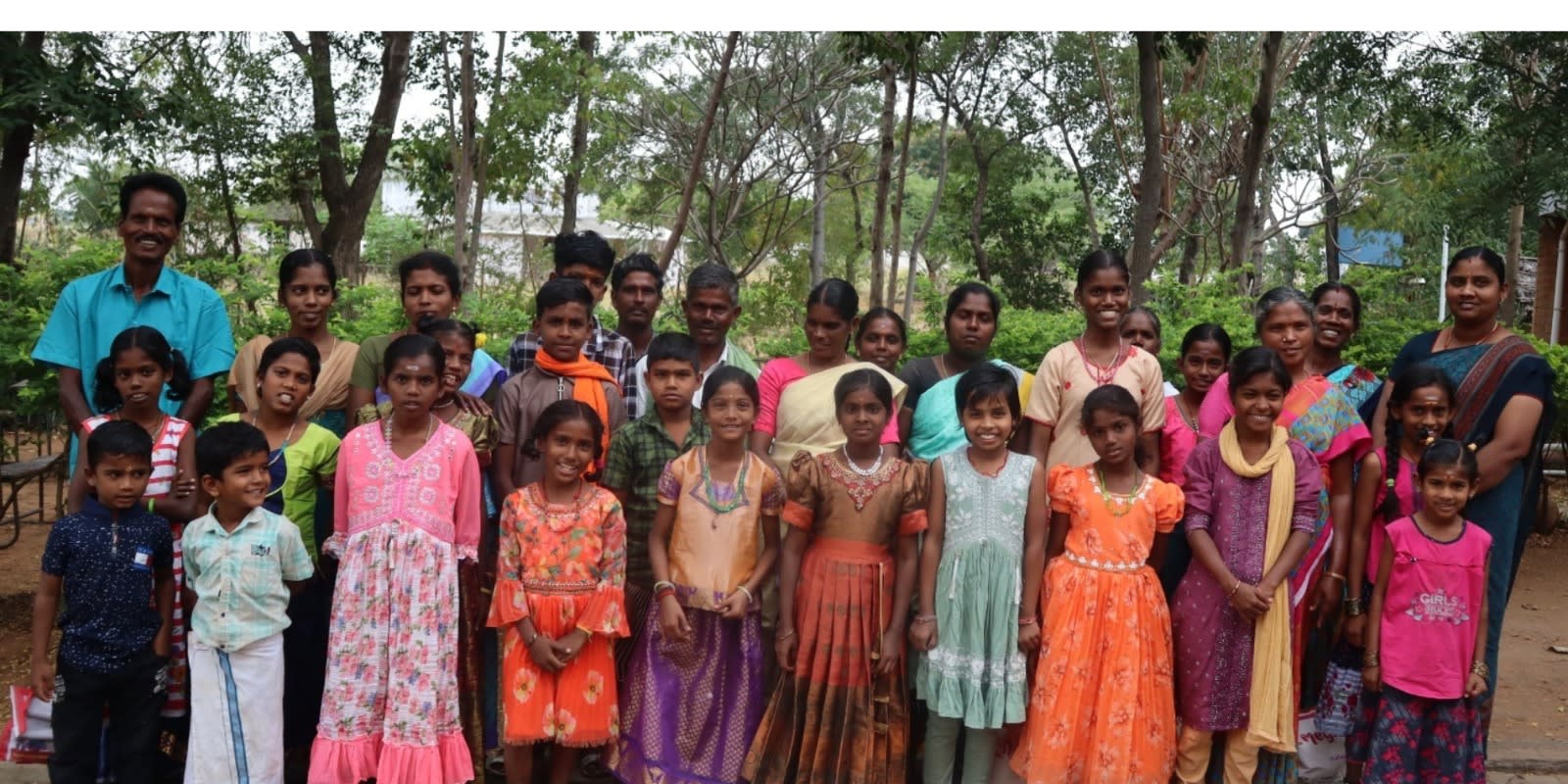 Group of rural children and community members standing together outdoors in Musiri Tamil Nadu, India, supported by SPPD programs.
