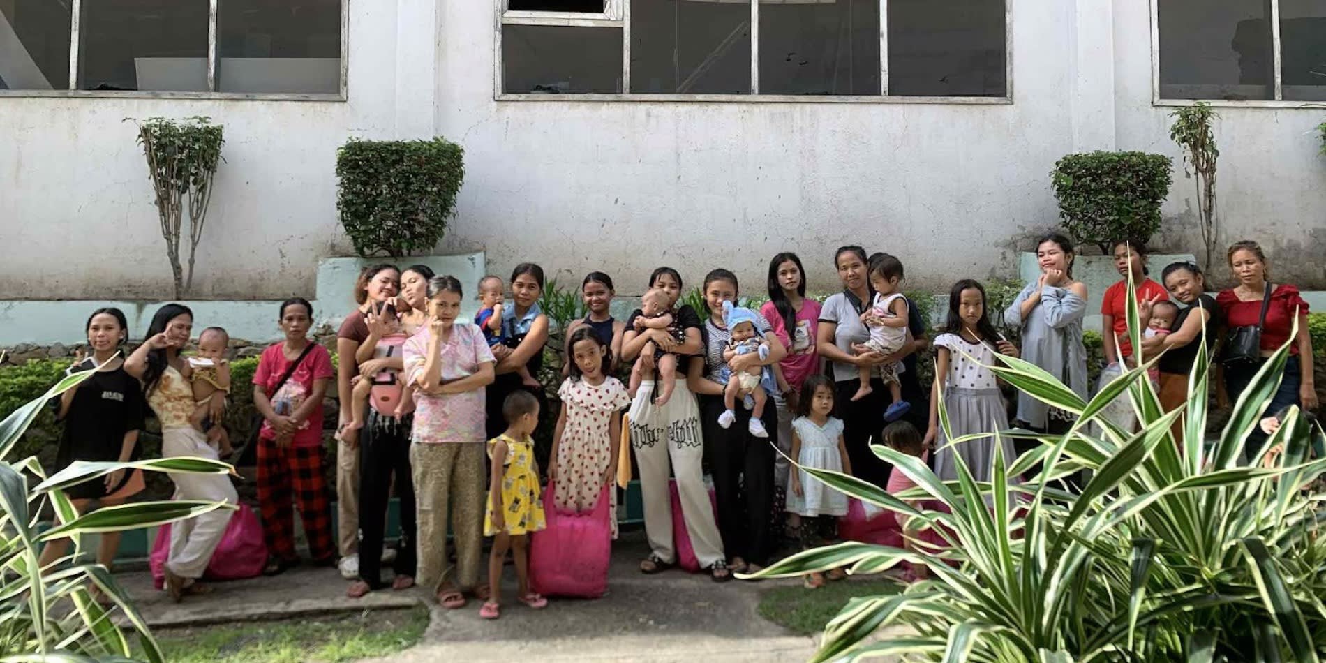 Girls and young mothers from LYF's program, some holding their babies, gathered outside a building in Cebu