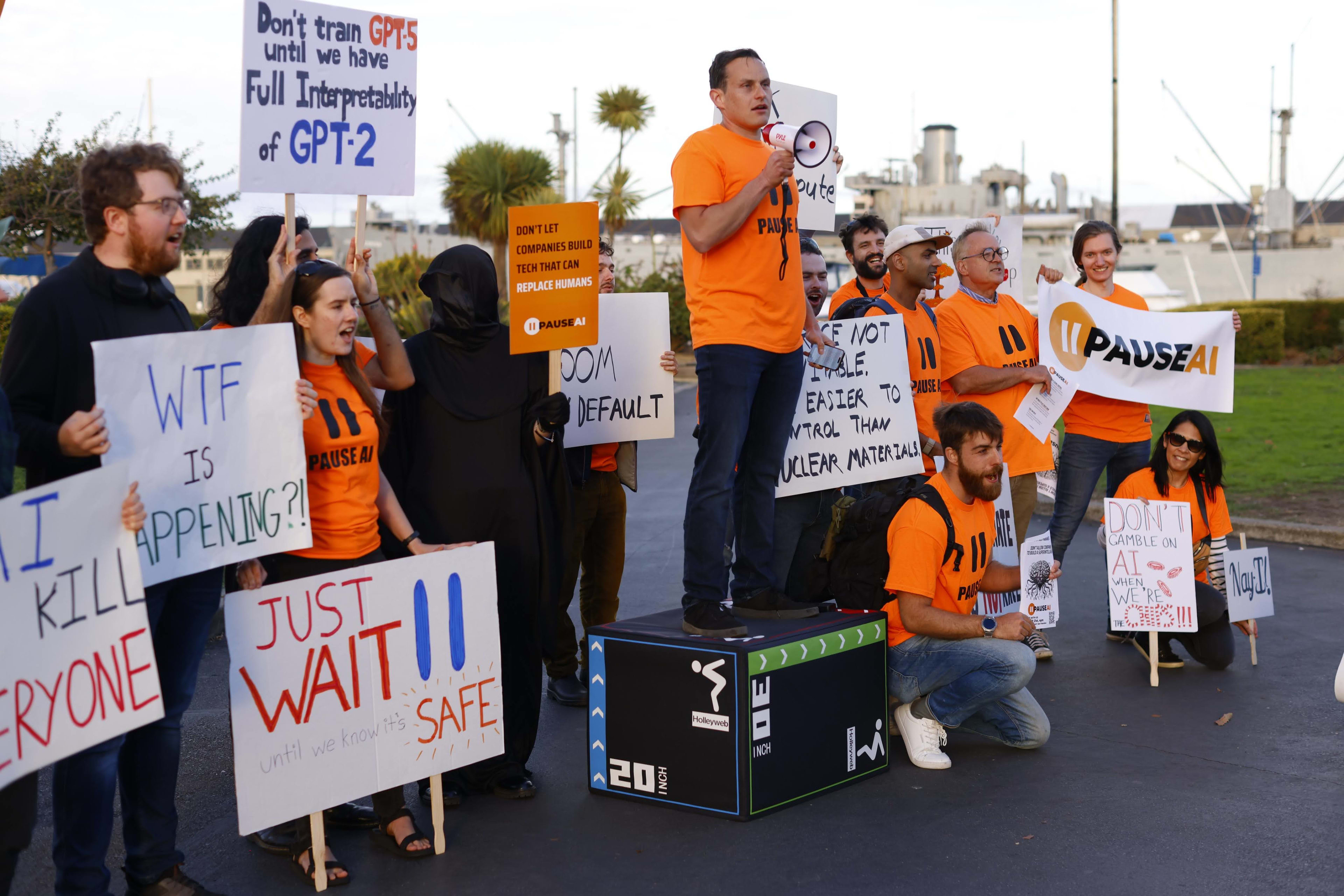 Group of community protesters with posters calling for a pause to dangerous AI development.