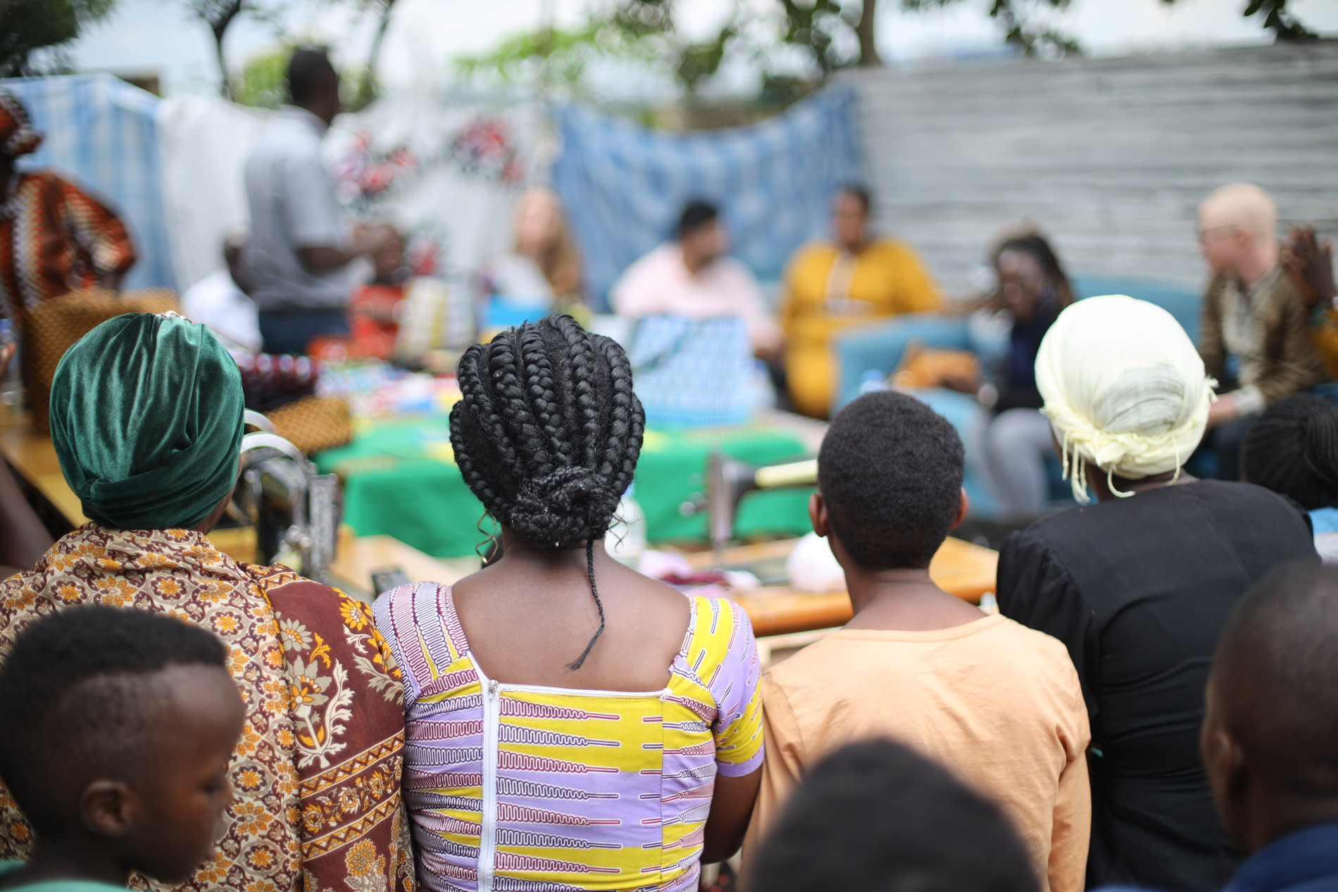 A group of women and children sit in a circle. 