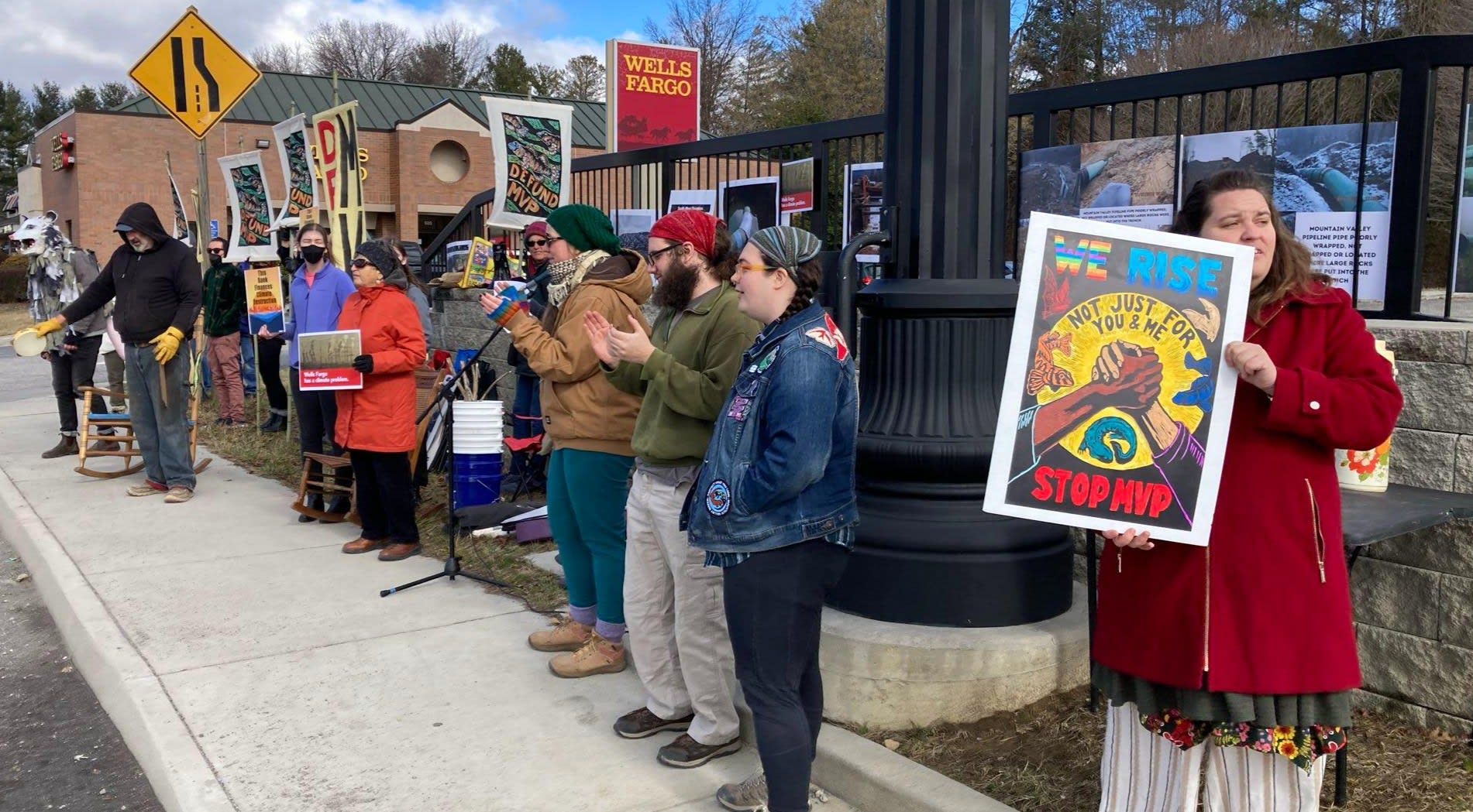 People holding banners that read Stop MVP. Mountains are in the background.