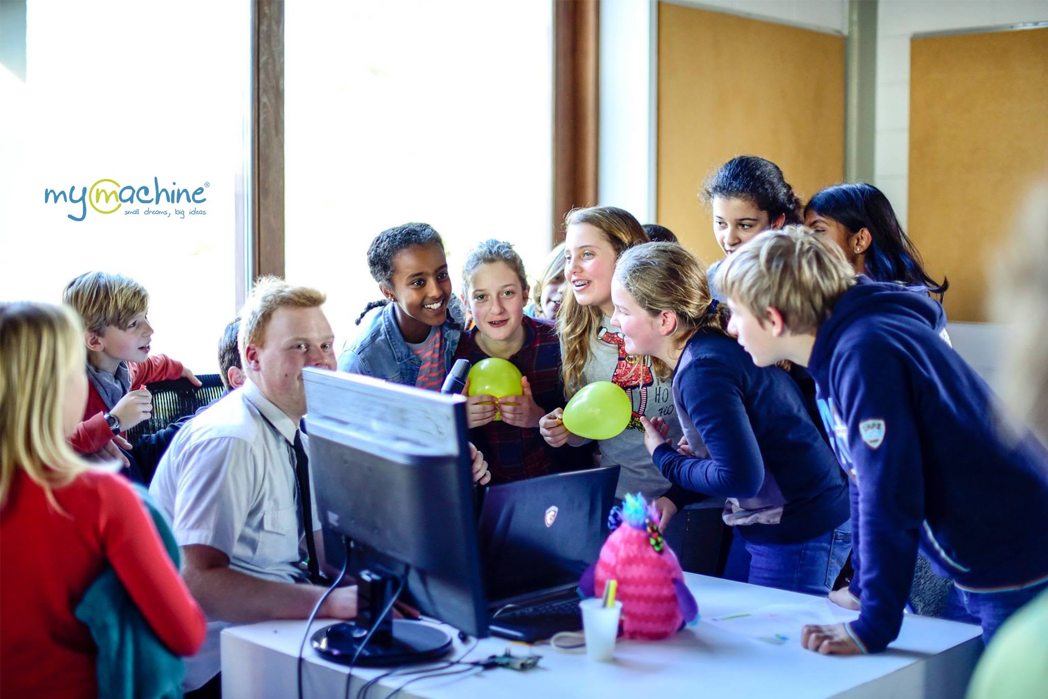 Picture showing university student co-creating a Dream Machine with 12 primary school students