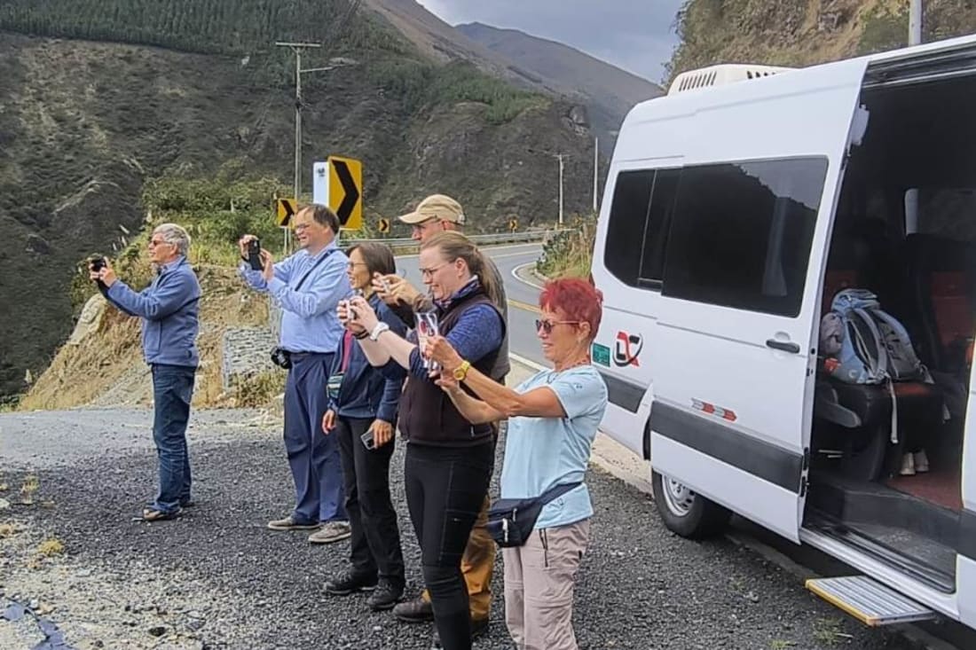Viajeros junto a una van de Dacartours en una parada de ruta