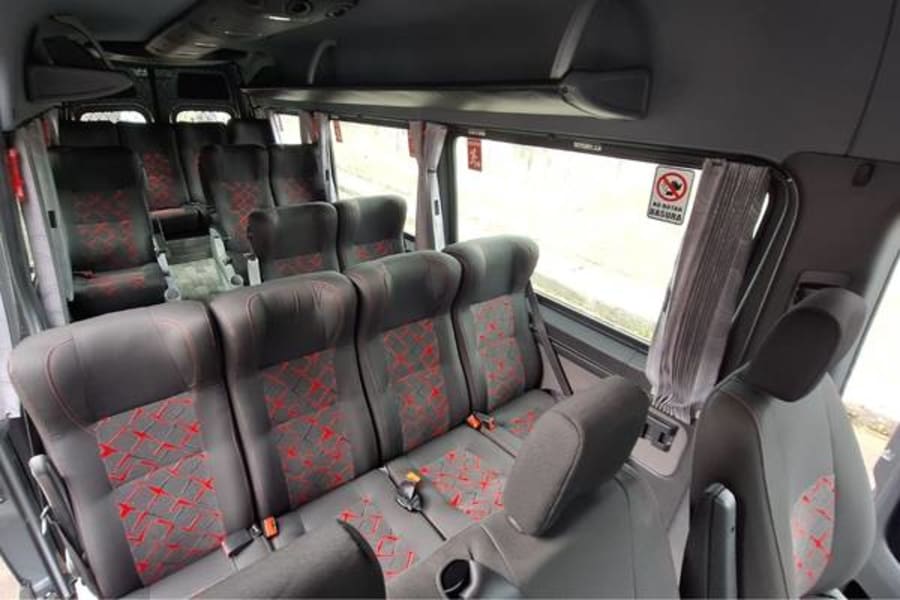 Interior de un minibús de Dacartours con asientos reclinables y espacio individual