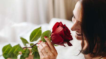 Hôtel Ermitage, 4 étoiles à Evian - Femme sentant une rose rouge en souriant